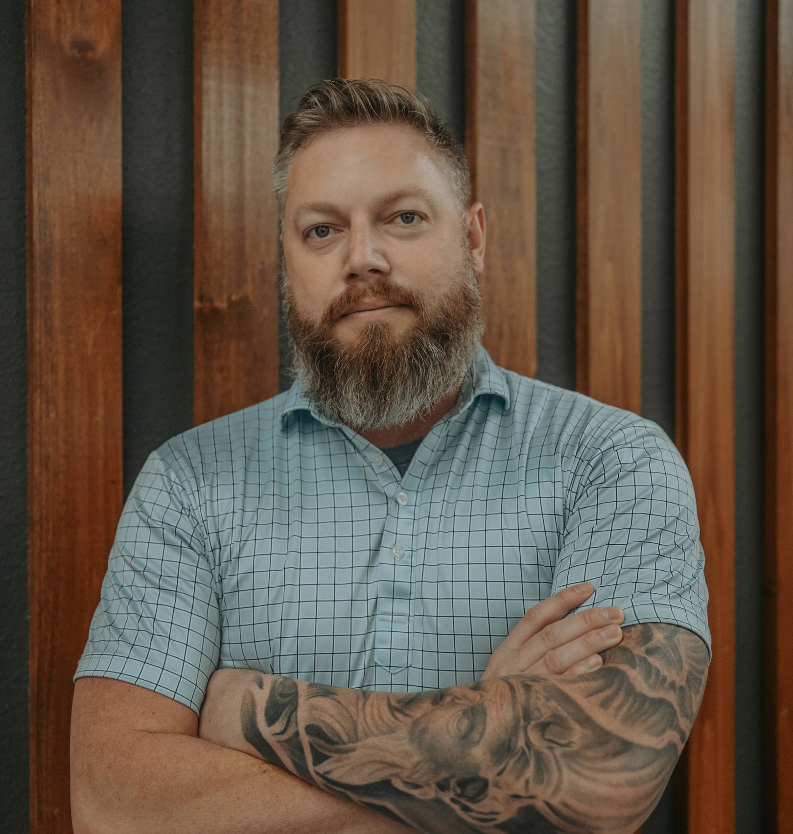 Four well-dressed professionals standing in a line in front of a wooded nature background.