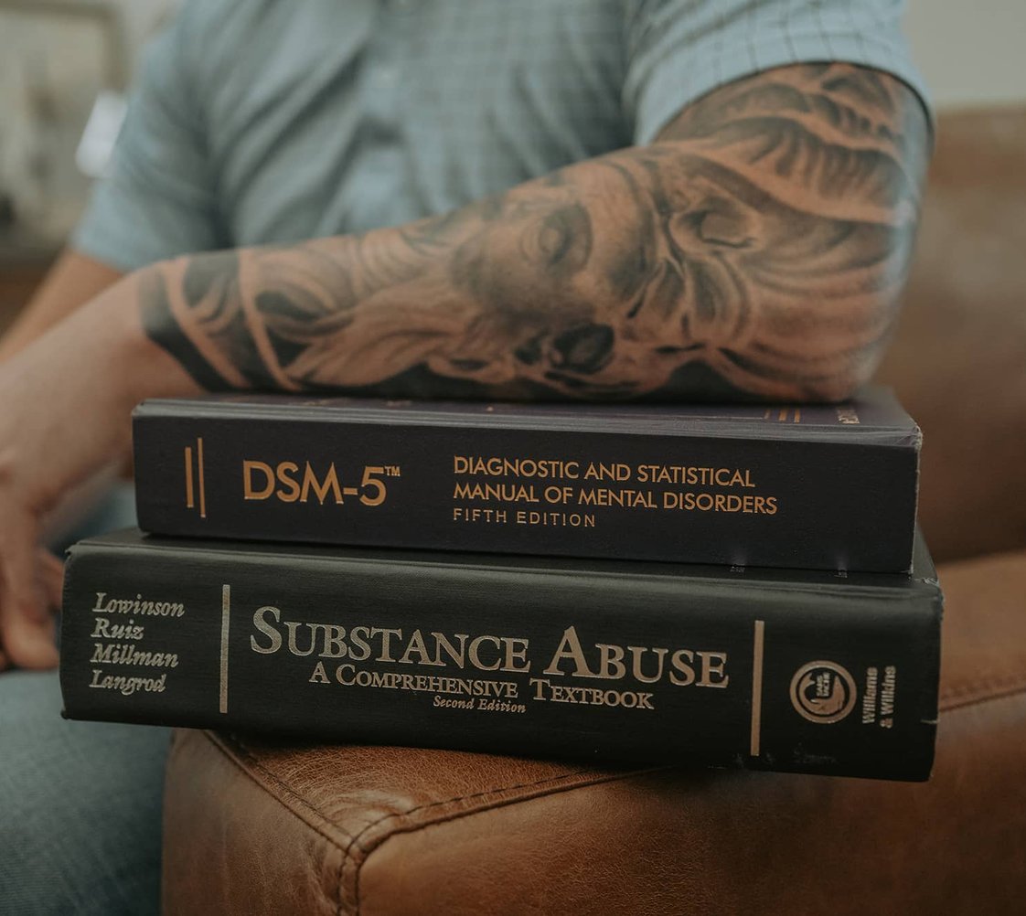 Three young adults seated and listening to an older professional.